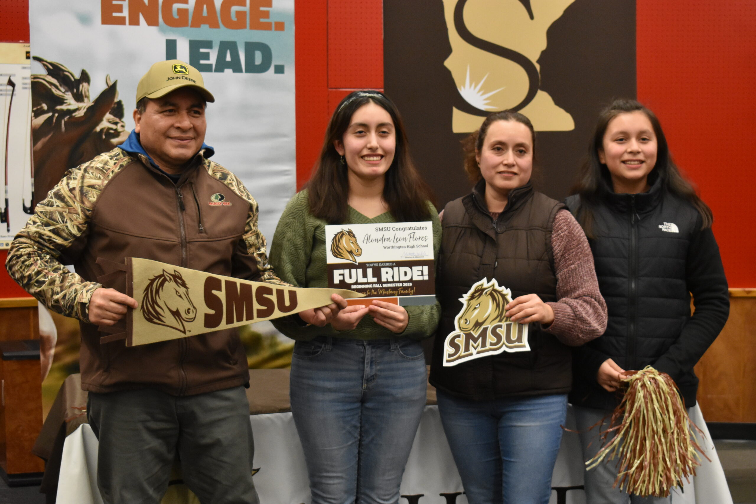 Alondra and her family holding SMSU banner and certificate